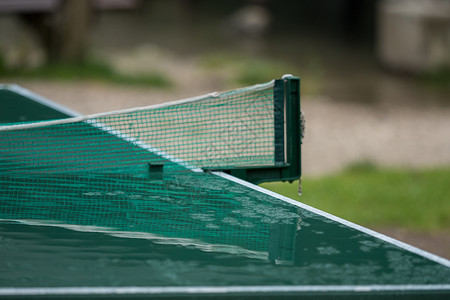 雨后一个湿桌网球板运动游戏雨滴天气乐趣公园球类青年桌子绿色背景图片
