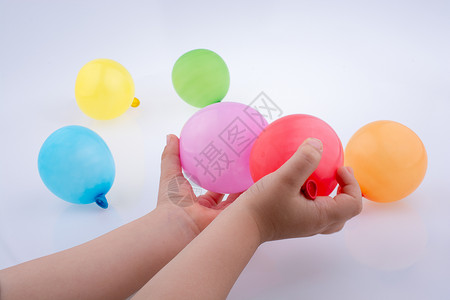 手握着一个多彩小气球气球生日塑料漂浮庆典橡皮白色乐趣细绳小样背景图片