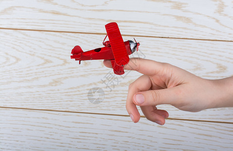手持玩具飞机在木质纹理上车辆运输商业航班喷射白色世界乘客旅行航空公司背景图片
