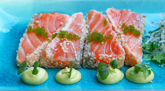 蓝色板块上新鲜生鲑鱼刺片沙拉海鲜盘子起动机食物餐厅桌子小吃美食背景图片