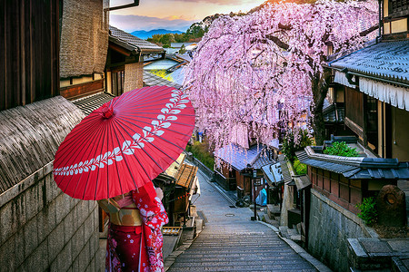 赏樱花之旅身穿日本传统和服的女人在日本京都的春日山区走过历史之旅街道浴衣旅行寺庙神社女孩樱花城市地标文化背景