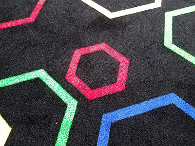 黑地毯或带有多彩六边形形状的地毯小地毯地面织物黑色背景图片