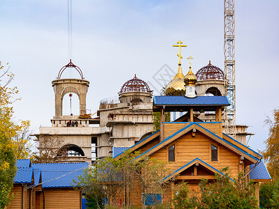 小金球小木木教堂 有蓝色屋顶和在大寺庙背景上的金球穹顶全景工作工程构造基础设施艺术金子景观起重机城市背景