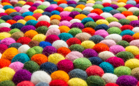 多色感觉球地毯细节纺织品绿色粉色软垫纤维橙子紫色手工业手工织物背景图片