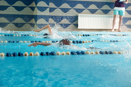 孩子们游自由式泳池 室内游泳池里有清蓝的水团队运动员男生男性竞赛水池孩子蓝色游泳者车道背景