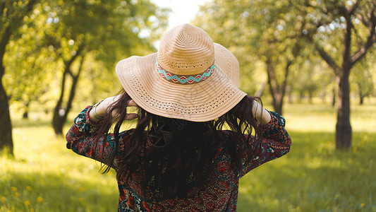 无檐帽穿着帽子和服装的漂亮时装女郎背部黑发公园檐帽女孩条纹情绪潮人旅行冒险旅游背景