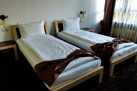 一间旅馆的卧室里有两个单人床位背景图片