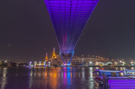 逆转Bhumibol大桥河大桥 打开灯光城市夜空戒指建筑学海景交通地标蓝色街道天空背景