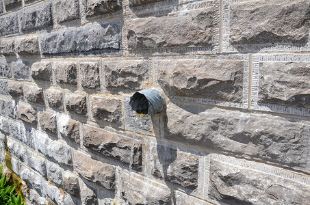 用灰砖墙从管里抽出的水排水管道灰色管子石头背景图片