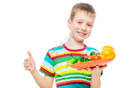 满意的男孩与一盘健康的蔬菜板 随心所欲地分离背景图片