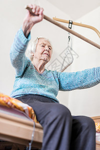 游子身上衣96岁的年长妇女用棍子在她坏的身上运动公民练习退休机构公寓医学女士服务帮助活动背景