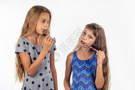 两个女孩吸焦糖糖果图片