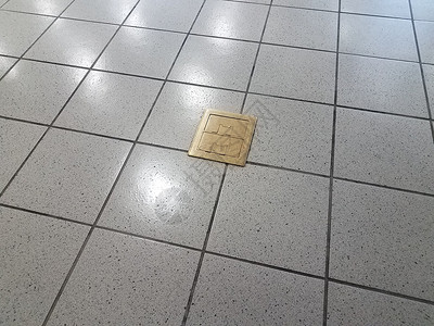 灰砖地板上的金属金属黄铜电气插口正方形灰色地面出口背景图片