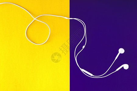 黄紫色背景上的白色耳机 从上面看小路娱乐工具艺术电话耳朵纸板音乐立体声技术背景图片