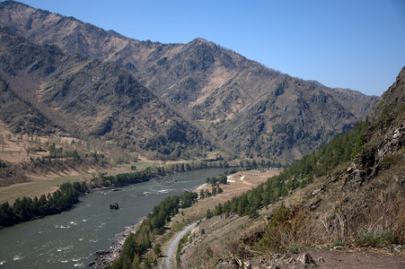 湍急的绿松石河在山脉的融合中流过山谷高清图片