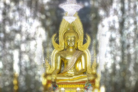 老挝佛像在瓦特大教堂玻璃处的金佛像宗教寺庙纪念碑雕塑王国冥想雕像金子微笑佛教徒背景