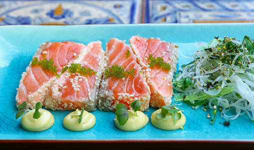蓝色板块上新鲜生鲑鱼刺片盘子小吃食物沙拉美食餐厅海鲜起动机桌子背景图片