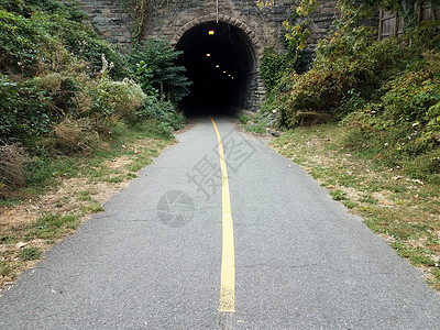 黑沥青通道或小路和暗隧道出口入口植物黄线沥青黑色踪迹背景图片