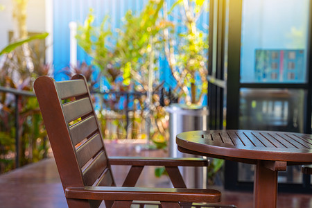 室外庭院椅子和桌子 带阳光的户外木制露台椅和桌子背景图片