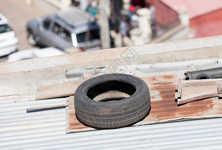旧轮胎放在锌屋顶的锌顶上 以防止锌被炸掉背景图片