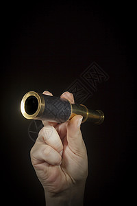 手握着间谍眼镜海军望远镜海洋单目玻璃金属放大镜镜片旅行青铜背景图片