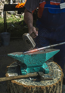 铁锤子铁匠在铁砧上锻打铁金属金工手工古董店铺工业职业锤子铁匠铺工艺背景