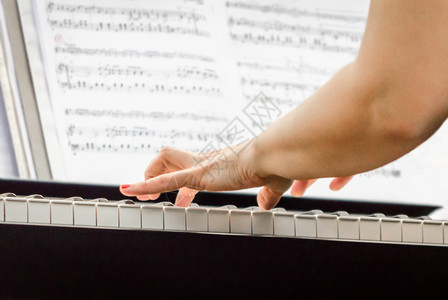 女钢琴音乐家和钢琴键紧紧关上女性乐队乐器展示皮革白色钥匙音符琴键音乐背景图片