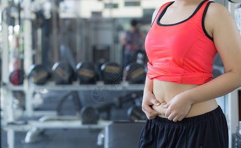 过量运动特写女人抱着过多的脂肪腹部 女人超重 abd手臂组织女性橘皮内衣身体运动健身房成人女士背景