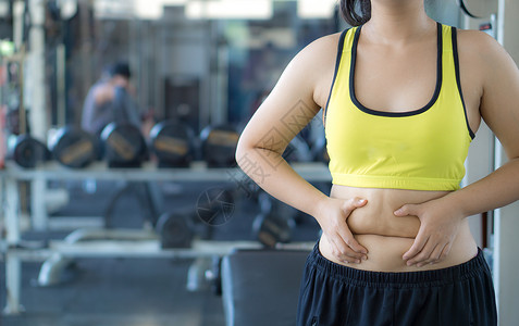 过量运动特写女人抱着过多的脂肪腹部 女人超重 abd成人暴饮暴食胸罩营养手臂健身房腰部损失身体运动背景