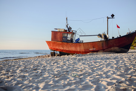 日出时在海滩上钓鱼船海岸线木头天空太阳旅行文化海洋海岸国家渔夫背景图片