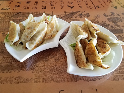 餐桌上的中国油炸午餐白色桌子锅贴面团盘子小吃食物背景图片