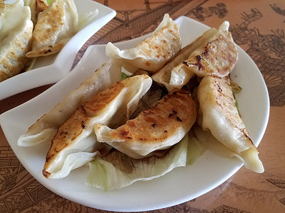 餐桌上的中国油炸锅贴小吃午餐食物白色面团盘子桌子背景图片