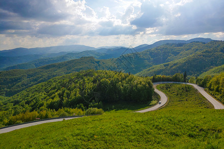 草国欧洲阿尔卑斯山的国路 自然沥青天空缠绕爬坡旅行季节国家车道草地森林背景
