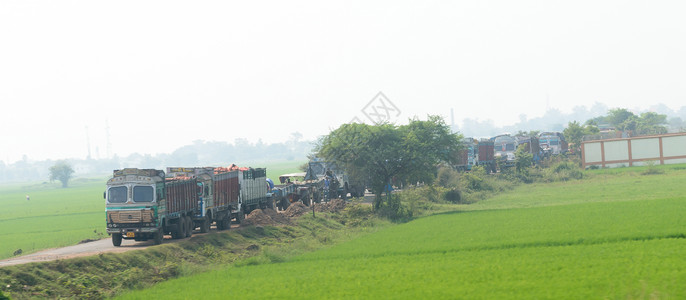 前进方向重型货车的长队交通车辆在乡村公路未铺砌的道路上排队等候 印度是世界上最大的陆路服务州际网络 印度西孟加拉邦 亚洲 2019 年背景