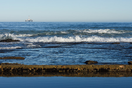 波浪切割平台带有近海平台的海岸潮泳池和岩礁背景