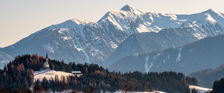 向阳坡山地景观 冬季清晨闪光的山丘教堂 大全景背景