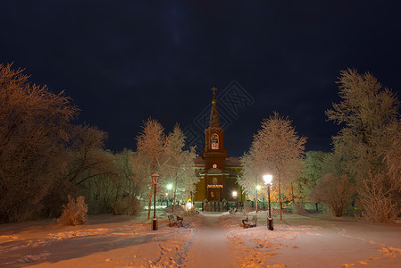 夜间东正教教堂的建筑被雪中树木环绕 周围是雪中的树木天空人行道教会分支机构雪堆灯光背景图片