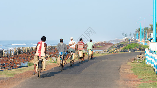 偏远沿海地区的一小群中青年骑着自行车下班回家 自行车是农村生活的主要交通方式 印度西孟加拉邦 2019 年 5 月团队服装体力劳背景图片