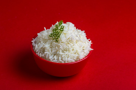 红背景的红碗里煮白纯白巴斯马提大米香米营养蒸汽盘子粮食美食纤维饮食食物午餐背景图片