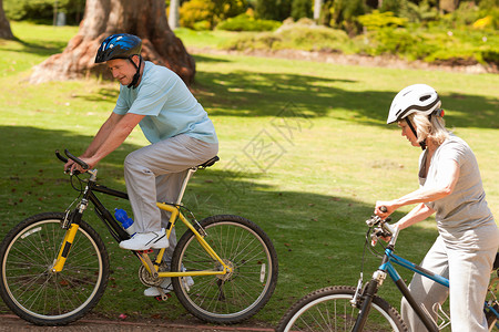 退休夫妇在户外骑山车两个人男人女性微笑男性老年农村女士享受公园背景图片