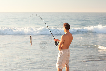 活人捕鱼海滨男性支撑娱乐爱好男人男生乐趣海洋海岸背景图片
