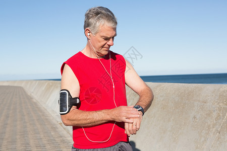 活跃的老年男子在码头上慢跑音乐享受训练退休蓝天手表晴天快乐海岸线运动服背景图片