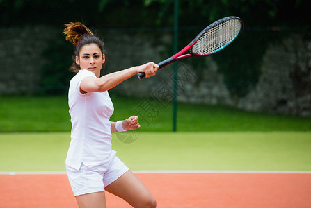 年轻打球网球手腕带白色活动女士闲暇专注球拍女性训练竞技背景