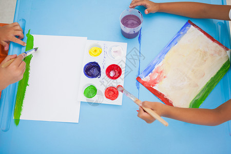 可爱的小男孩在课堂上桌边画画班级红色画笔围裙早教绘画教育创造力男生艺术类背景