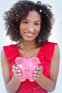 黑发女人持有小猪银行的复合形象红色粉色雪花计算机快乐绘图微笑下雪女士棕色背景图片
