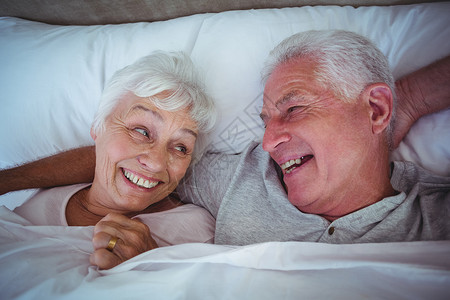 岁月已老躺在床上的一对老夫妇笑着躺在床上背景