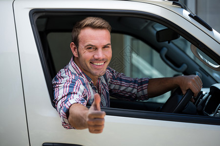 车标志年轻人举起拇指标志手势男性服装汽车前座快乐旅行旅游男人驾驶背景