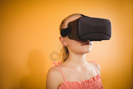 使用虚拟现实设备的女孩Name服装耳机未来派技术电子娱乐电脑女性休闲黄色背景图片