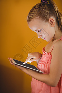 小女孩使用平板电脑女性休闲女孩科技头发滚动服装触摸屏药片技术背景图片
