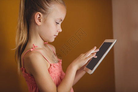 小女孩使用平板电脑科技服装药片触摸屏休闲幸福头发育儿黄色滚动背景图片
